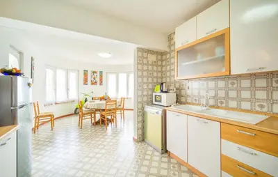 a kitchen with white cabinets and a dining room at Nice Apartment In Palermo in Palermo