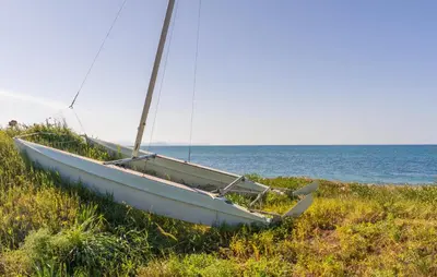 a boat sitting in the grass on the beach at Stunning Apartment In Trappeto in Trappeto