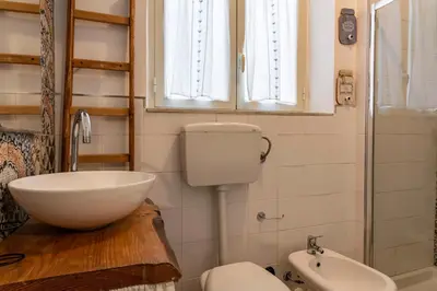 a bathroom with a toilet and a sink at GuestHost - Castrum Lodge - Ballarò Stylish Apartment in Palermo