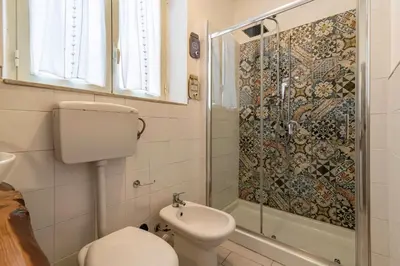 a bathroom with a toilet and a shower at GuestHost - Castrum Lodge - Ballarò Stylish Apartment in Palermo