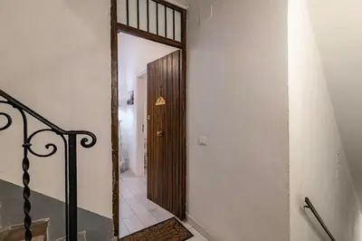 a hallway with a wooden door and a stairway at GuestHost - Castrum Lodge - Ballarò Stylish Apartment in Palermo