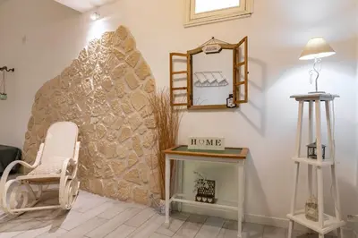 a room with a chair and a mirror and a fireplace at GuestHost - Castrum Lodge - Ballarò Stylish Apartment in Palermo