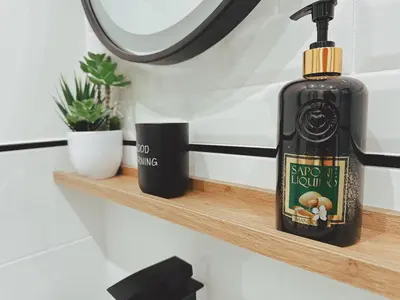 a bottle of soap on a wooden shelf in a bathroom at Sicania - In centro Storico a Palermo in Palermo