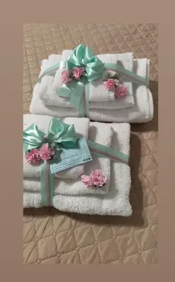 three towels with flowers on them on a bed at Palermo Centro Gaale in Palermo