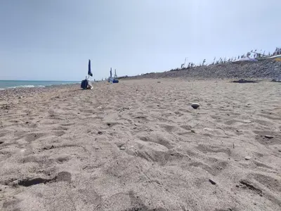a sandy beach with footprints in the sand at Cento Pini Holiday Cefalù in Buonfornello