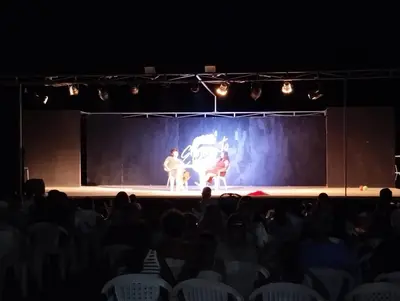 an audience watching two men on a stage at Cento Pini Holiday Cefalù in Buonfornello