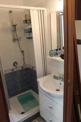 a small bathroom with a sink and a shower at Cento Pini Holiday Cefalù in Buonfornello