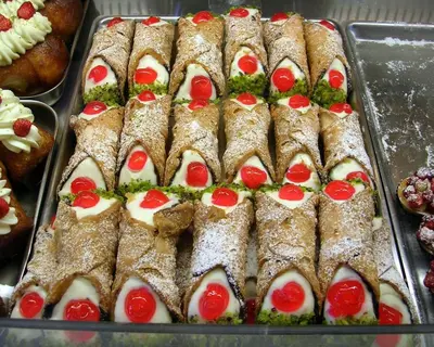 a tray of pastries with tomatoes on top of them at Cento Pini Holiday Cefalù in Buonfornello