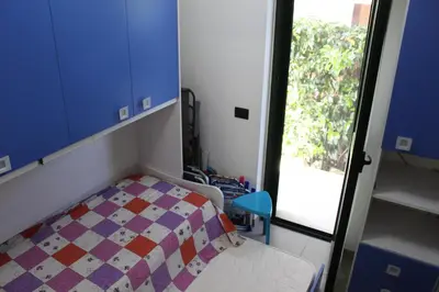 a small bedroom with a bed and a window at Cento Pini Holiday Cefalù in Buonfornello