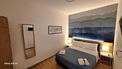 a bedroom with a bed and a painting on the wall at Nicasa, accogliente appartamento nel cuore di Palermo in Palermo