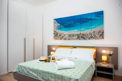 a bedroom with a bed with a painting on the wall at Appartamenti Carella Sicilia in Palermo