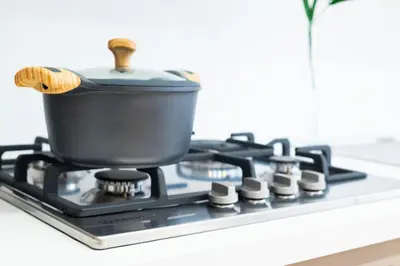 a pot on a stove top with a wooden spoon at Appartamenti Carella Sicilia in Palermo