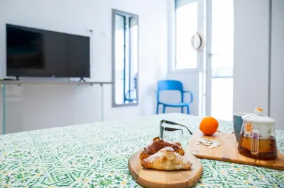 a cutting board with a pastry and an orange on a table at Appartamenti Carella Sicilia in Palermo