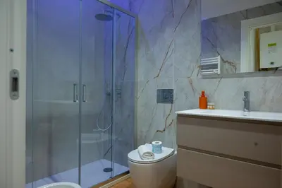 a bathroom with a shower and a toilet and a sink at Appartamenti Carella Sicilia in Palermo