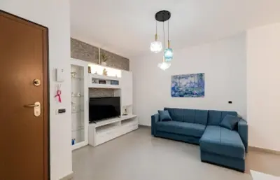 a living room with a blue couch and a tv at Paradiso del mare, Appartamento accogliente vicino a mare, metro, aeroporto e Palermo in Capaci