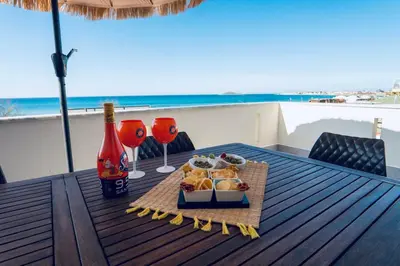 a table with a plate of food and a bottle of wine at DV holiday home in Isola delle Femmine