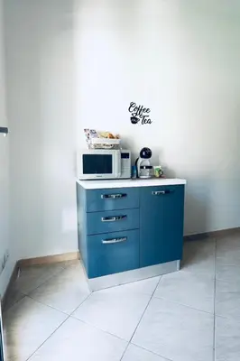 a kitchen with a blue cabinet with a microwave on it at DV holiday home in Isola delle Femmine