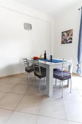 a dining room with a white table and chairs at DV holiday home in Isola delle Femmine
