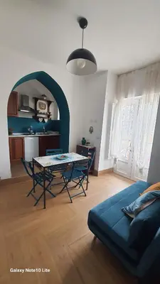 a living room with a table and a blue couch at Le Calette Palermo in Palermo