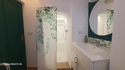 a bathroom with a shower curtain with a sink at Le Calette Palermo in Palermo