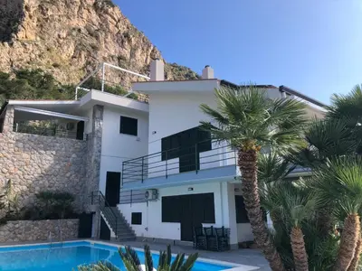 a house with a swimming pool next to a mountain at VFH Residence Flavia -Tre Piscine in Santa Flavia
