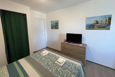 a bedroom with a bed and a flat screen tv at VFH Residence Flavia -Tre Piscine in Santa Flavia