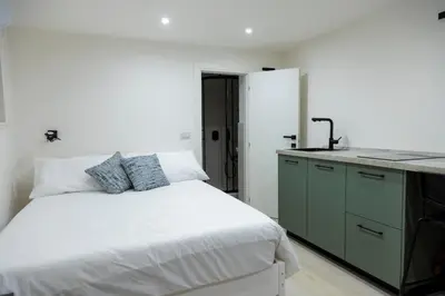 a white bedroom with a bed and a sink at Stratuzza Apartments in Palermo