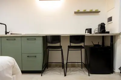 a kitchen with two bar stools under a counter at Stratuzza Apartments in Palermo