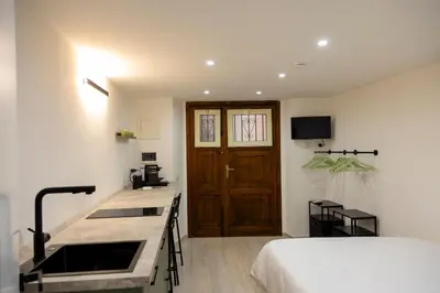 a room with a bed and a kitchen with a sink at Stratuzza Apartments in Palermo