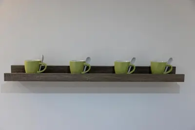 a shelf with four coffee cups and spoons on it at Stratuzza Apartments in Palermo