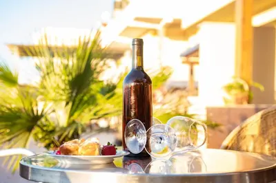 a bottle of wine and a plate of food on a table at Liberia vacanze - A POCHI PASSI dal mare in Alcamo