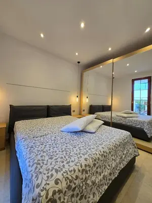 a bedroom with a bed and a large mirror at Villa Lumos Mondello Beach in Palermo