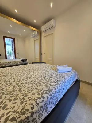a bedroom with a large bed with a blue comforter at Villa Lumos Mondello Beach in Palermo