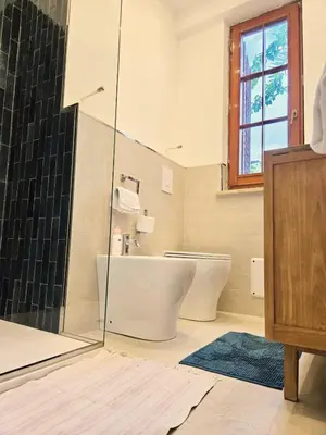a bathroom with two toilets and a glass shower at Villa Lumos Mondello Beach in Palermo