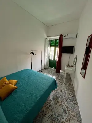 a bedroom with a green bed and a window at Cortile Siciliano in Palermo