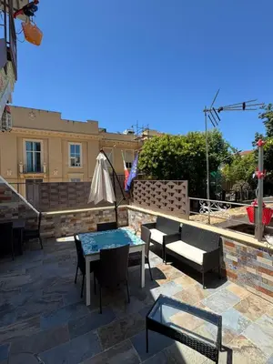 a patio with a table and chairs and a building at Cortile Siciliano in Palermo