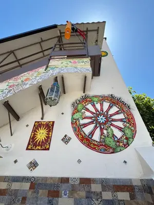 a mural on the side of a house with a ferris wheel at Cortile Siciliano in Palermo