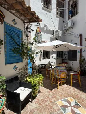 a patio with a table and an umbrella and chairs at Cortile Siciliano in Palermo