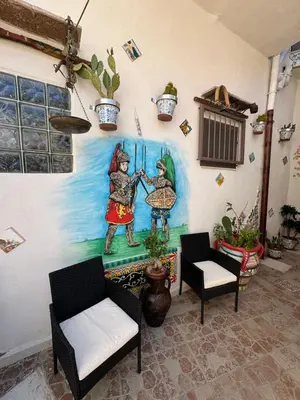 a painting of two women on a wall with chairs at Cortile Siciliano in Palermo