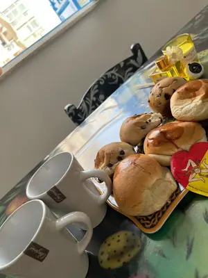 a table with a plate of pastries and a coffee mug at Cortile Siciliano in Palermo
