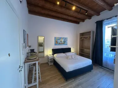 a bedroom with a bed with a ladder and a mirror at Tuppulia appartamenti in Palermo
