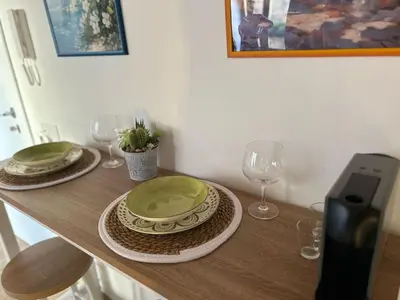 a table with plates and wine glasses on it at Tuppulia appartamenti in Palermo