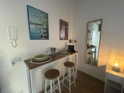 a kitchen with a bar with stools and a mirror at Tuppulia appartamenti in Palermo