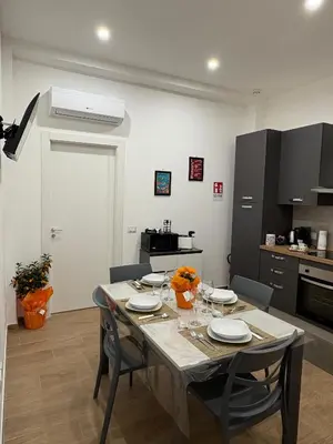 a kitchen with a table with chairs and a dining room at Residenza Stabile 64 in Palermo