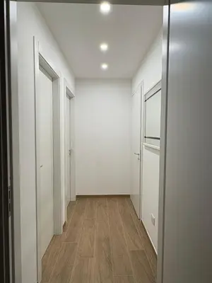an empty hallway with white walls and wood floors at Residenza Stabile 64 in Palermo