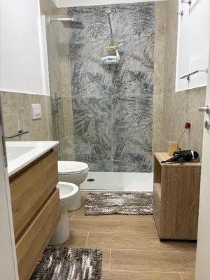 a bathroom with a shower and a toilet and a sink at Residenza Stabile 64 in Palermo
