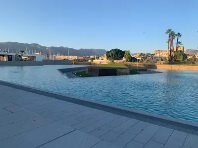 a large pool of water with buildings in the background at Mondello Key loft in Palermo