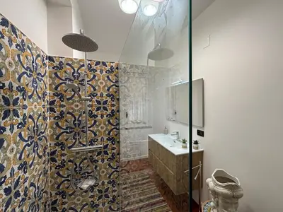a bathroom with a glass shower with a sink at Mondello Key loft in Palermo