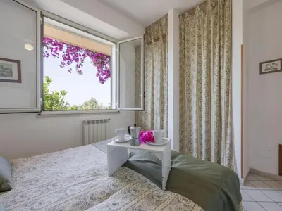 a bedroom with a bed with a table and a window at Apartment Cicladi Leros by Interhome in Santa Flavia