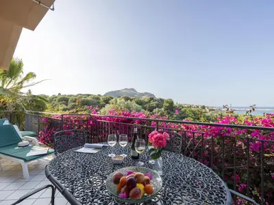 a table with a bowl of fruit and wine glasses at Apartment Cicladi Santorini by Interhome in Santa Flavia
